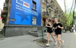 Des joggeurs passent devant une affiche annonçant le sommet de la Communauté politique européenne le 2 mai 2026 à Erevan 