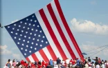 Des partisans de Donald Trump devant un drapeau américain taille XXL, à Butler, le 13 juillet 2024