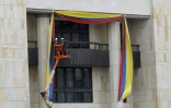 Des ouvriers mettent en place des banderoles aux couleurs du drapeau colombien sur la façade du palais de Justice de Bogota, à la veille de la cérémonie d'investiture du nouveau président, Ivan Duque, le 6 août 2018