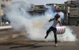 Casque de moto sur la tête, un Irakien court pour échapper aux gaz lacrymogènes, lors d'une manifestation contre le pouvoir, à Bagdad le 7 novembre 2019