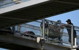 Un sans-abri pousse un chariot rempli d'affaires, sur un pont près d'un campement de SDF, à Los Angeles, le 1er juin 2026