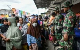 Des habitants de Palu, aux Célèbes, font la queue le 7 octobre 2018 pour recevoir de l'aide après le séisme suivi d'un tsunami qui a ravagé l'île.