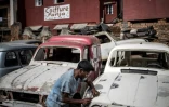 Un jeune carrossier travaille sur une Renault 4L à Antoamadikina, un quartier d'Antananarivo, le 6 novembre 2018 à Madagascar
