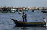 Des Palestiniens agitent leur drapeau sur un bateau de pêche tandis qu'ils prennent la mer le 29 mai 2018 depuis le port de Gaza 