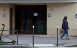 Une femme passe devant un immeuble où des étoiles de David ont été taguées dans la nuit, dans le quartier d'Alésia, à Paris, le 31 octobre 2023