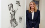 Paula Head, directrice générale de l'hôpital de Southampton, devant l'oeuvre "Game Changer" de l'artiste Banksy, le 7 mai 2020 à Southampton