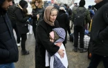 Une femme réconforte un enfant en attendant un mode de transport à un poste frontière entre la Moldavie et l'Ukraine près de la ville de Palanca le 1e mars
