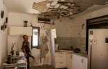 Un soldat israélien inspecte une maison touchée par une roquette du Hezbollah dans le village de Kiryat Shmona, dans le nord d'Israël, le 16 juin 2024