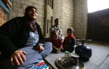 La Syrienne Oum Walid (g), 52 ans, avec ses petits-enfants dans la pièce d'un bâtiment en construction où elle vit avec ses cinq enfants et leurs familles à Jaramana, dans la banlieue de Damas, le 16 décembre 2015