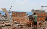 Des membres de la famille syrienne des Bahlawan aident à la construction d'un bateau en bois au bord de l'île d'Arwad, dans l'ouest de la Syrie, le 24 juillet 2022