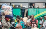 Des passagers ougandais font la queue à une gare routière pour retourner voter dans leur village, à Kampala le 12 janvier 2021