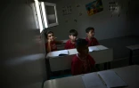 Des jeunes enfants suivent une leçon d'anglais dans une classe installée dans un conteneur dans le camp de réfugiés de Skaramangas (sud d'Athènes), le 24 juin 2016