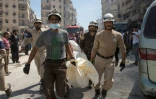 Des morts évacués des décombres après un bombardement le 23 avril 2016 à Alep en Syrie