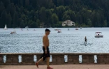Un homme marche le long du lac de Gérardmer, dans l'est de la France, le 3 août 2022, alors que le niveau d'eau du lac a baissé suite à une vague de chaleur 