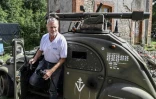 L'Américain Grégory Marshall et l'une de ses 2CV relookée en char d'assaut, dans l'ancienne gare de Dracy-Saint-Loup, le 11 juillet 2017 en Saône-et-Loire