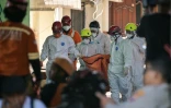 Des membres des équipes de secours transportent un sac mortuaire sur le site de l'effondrement de l'internat islamique Al Khoziny à Sidoarjo, dans l'est de Java, le 6 octobre 2025 en Indonésie