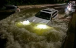 Une voiture s'engouffre dans une autoroute inondée à Brooklyn, le 2 septembre 2021