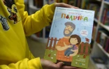 La libraire montre un livre pour enfant, Ă Lviv le 20 avril 2022