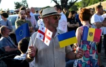 Un homme brandit des drapeaux de l'Union européenne et de l'Ukraine, entre autres, en Géorgie, à Tbilissi le 16 juin 2022