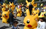 Des enfants posent au milieu d'un défilé de Pikachu à Yokohama au Japon le 7 août 2016.
