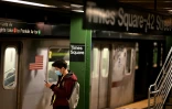 Un homme portant un masque de protection sur le quai du métro à la station de Times Square, le 13 mars 2020 à New York