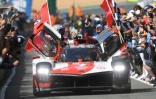 La Toyota N.7, pilotée par le Japonais Kamui Kobayashi, entouré de ses coéquipiers l'Argentin José Maria Lopez et le Britannique Mike Conway (d), après la victoire aux 24H du Mans, le 22 août 2021