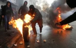 Des Palestiniens brûlent des pneus lors d'affrontements avec les forces de l'ordre israéliennes le 29 octobre 2015 à Hébron
