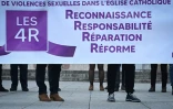 Des membres du collectif Les 4 R réclament justice devant la basilique Notre-Dame-du-Rosaire à Lourdes, le 6 novembre 2021