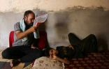 Un homme tente de rafraîchir son fils, à Hilla, dans le centre de l'Irak, le 10 août 2025
