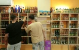 Des clients regardent des bouteilles d'alcool en vente dans un magasin de Qamichli, ville kurde du nord-est de la Syrie, le 18 août 2026