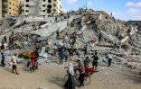 Des Palestiniens cherchent des objets à récupérer sur le site de l'effondrement de la tour Soussi, détruite par des bombardements israéliens, à Gaza, le 6 septembre 2025