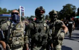 Des agents masqués de la patrouille frontalière des douanes et de la protection des frontières des États-Unis (CBP) derrière cordon de police à Chicago, le 4 octobre 2025 dans l'Ilinois