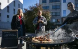Des passants observent la préparation d'un plat à Hägersten, au sud de Stockholm, lors d'une initiative visant à sensibiliser aux repas qui peuvent être préparés dans des conditions d'état d'urgence, le 23 septembre 2025 en Suède