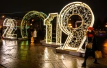 Une femme marche dans le centre de Moscou devant des chiffres illuminés annonçant la nouvelle année 2019, le 30 décembre 2018