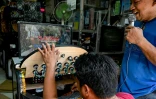 Un homme assemble une machine à karaoké dans une boutique de Manille, le 22 juillet 2023 aux Philippines