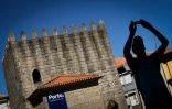 Un touriste prend une photo près des tours Pitoes à Porto, le 25 juillet 2016