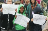 De jeunes migrants posent avec des affichettes réclamant leur départ pour le Royaume-Uni, le 26 octobre 2016, dans la "Jungle" de Calais