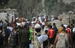 Déplacés palestiniens transportant des sacs d'aide humanitaire après une distribution à Nousseirat, dans le centre de la bande de Gaza, le 26 juillet 2025