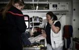 Pascale Martinet (d), infirmière anesthésiste et membre de l'une des premières unités hospitalières mobiles paramédicales (UMH-P) du CHU de Bordeaux, parle au téléphone dans un camion de pompiers utilisé pour transporter un patient suite à un appel d'urgence, le 17 avril 2024 à Bordeaux