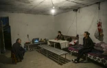 Une famille regarde la télévision dans un abri aménagé dans une cave, le 9 octobre 2020 à Martouni, dans la région disputée du Nagorny-Karabakh