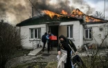 Des personnes sortent des affaires d'une maison en feu après un bombardement russe à Irpin, en Ukraine, le 4 mars 2022