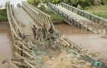 Des soldats de l'armée nationale de Somalie (SNA) sur un pont enjambant le fleuve Shabelle, détruit par les rebelles islamistes somaliens shebab, près de la localité de Bariire, le 11 novembre 2025