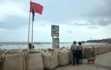 Un drapeau rouge interdisant la baignade sur la Grande plage de Biarritz, protégée par des sacs remplis de sable, le 26 août 2025, en prévision de la forte houle attendue