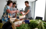 Une employée de la RATP achète des légumes produits par la start-up Aeromate sur le toit d'un bâtiment de la régie des transports à Paris, le 24 août 2017 