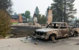Une voiture calcinée devant les ruines d'une maison rasée par les flammes, à Spokane, dans l'Etat de Washington, le 2 août 2026