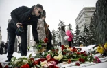 Des gens déposent des fleurs en hommage à l'opposant russe Alexeï Navalny devant le momument en mémoire des victimes de la répression politique, le 17 février 2024 à Moscou