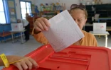 Une Tunisienne glisse son bulletin dans l'urne, lors des législatives, le 6 octobre 2019 à Tunis