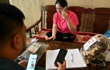 L'agriculteur Luong Quang Dai (g) et sa femme vérifient les commandes des produits qu'ils vendent sur la chaîne TikTok de Dai, dans leur maison de la province de Bac Kan, le 17 octobre 2023 au Vietnam