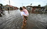 Des habitants dans une rue inondée de Batabano, dans la province de Mayabeque, à Cuba, le 7 novembre 2024 après le passage de l'ouragan Rafael