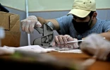 Un bénévole fabrique des visières de protection contre le Covid-19 pour les offrir aux médecins dans un ancien atelier de couture, le 28 octobre 2020 à Caracas, au Venezuela